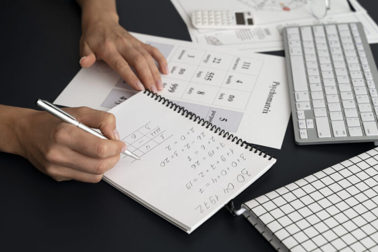 Person making numerical notes in a notebook.