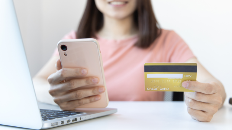 Girl holding a student credit card and smartphone.