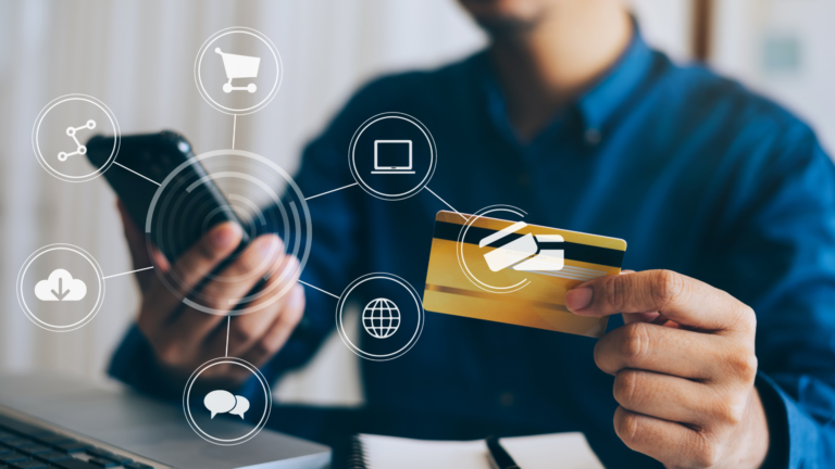 Man holding a credit card in one hand and cell phone in the other hand.