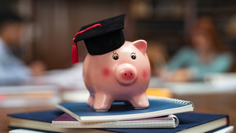 Illustrative image showing a piggy bank with a student hat on its head and on top of books.