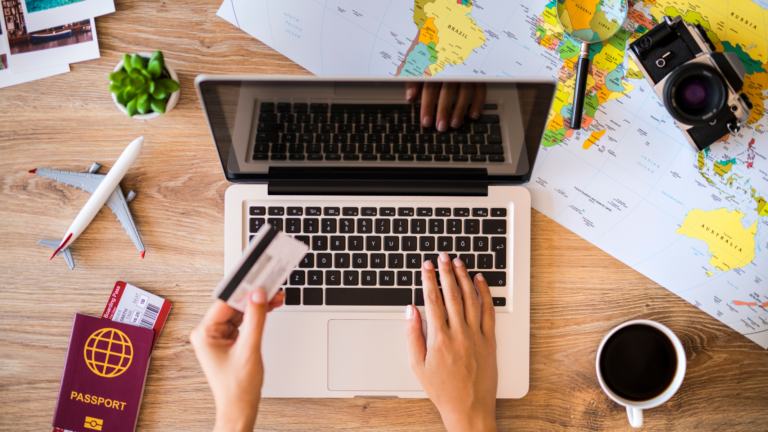 A person holding a credit card and using a notebook.