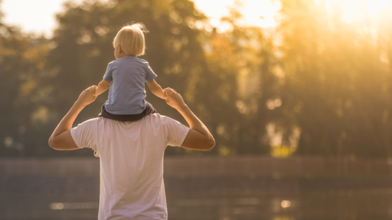 Man carrying a child on his back.